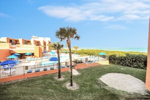 Relax by the pool surrounded by lush greenery and comfortable lounge chairs.