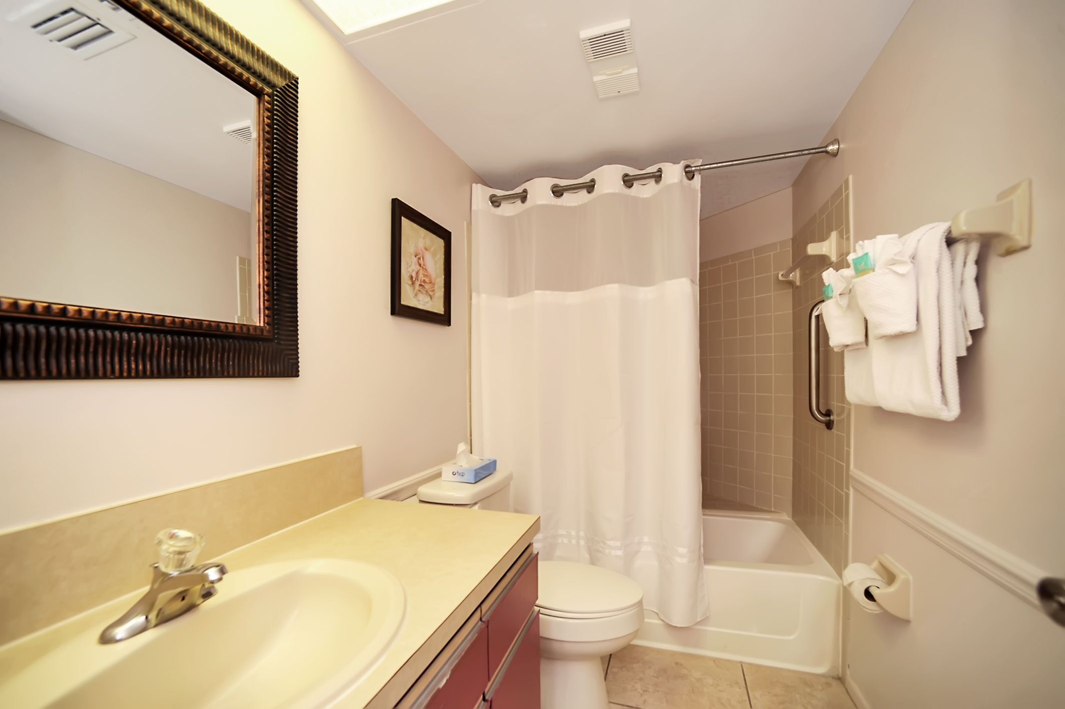 A bathroom with a sink, toilet, shower, and bathtub.