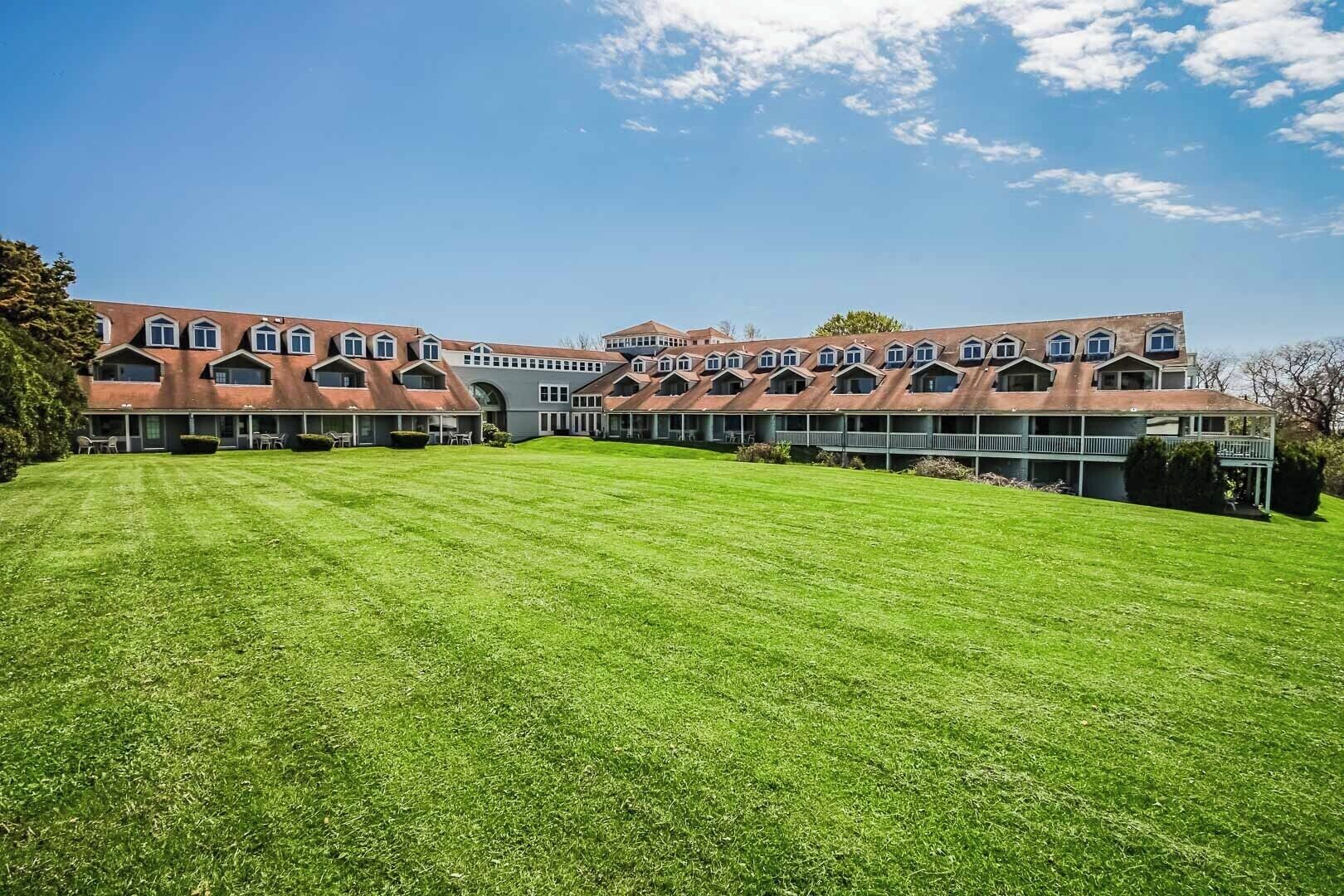 Un grand immeuble à étages, doté d’une façade symétrique, de nombreux balcons et d’une pelouse bien entretenue à l’avant.
