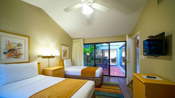 A hotel room with two beds, a ceiling fan, a TV, and a view of the outside. - Beachside Rental w/ Balcony & Pool (Boca Raton)