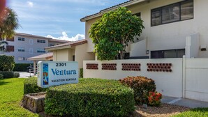 A sign for '2301 Ventura Vacation Rentals' with a well-maintained lawn and a large tree in front. - Beachside Rental w/ Balcony & Pool (Boca Raton)