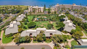 Un resort con varias construcciones, una piscina y vista al océano.