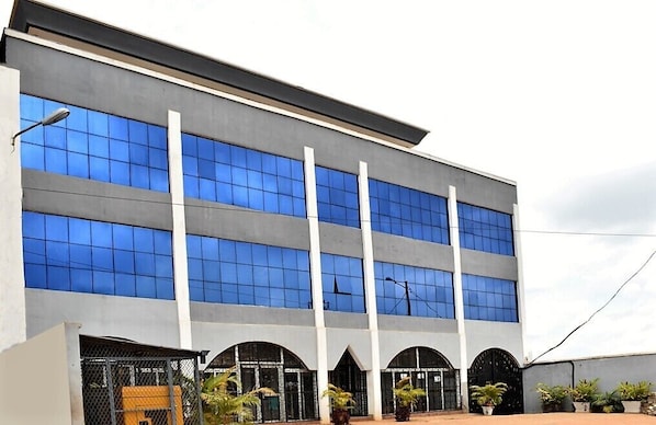 A modern building with multiple floors, large windows, and a flat roof.