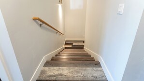 A staircase with wooden steps and a handrail, leading to a landing with a light switch. - New! Home located off Flathead River with balcony & fireplace (Columbia Falls)
