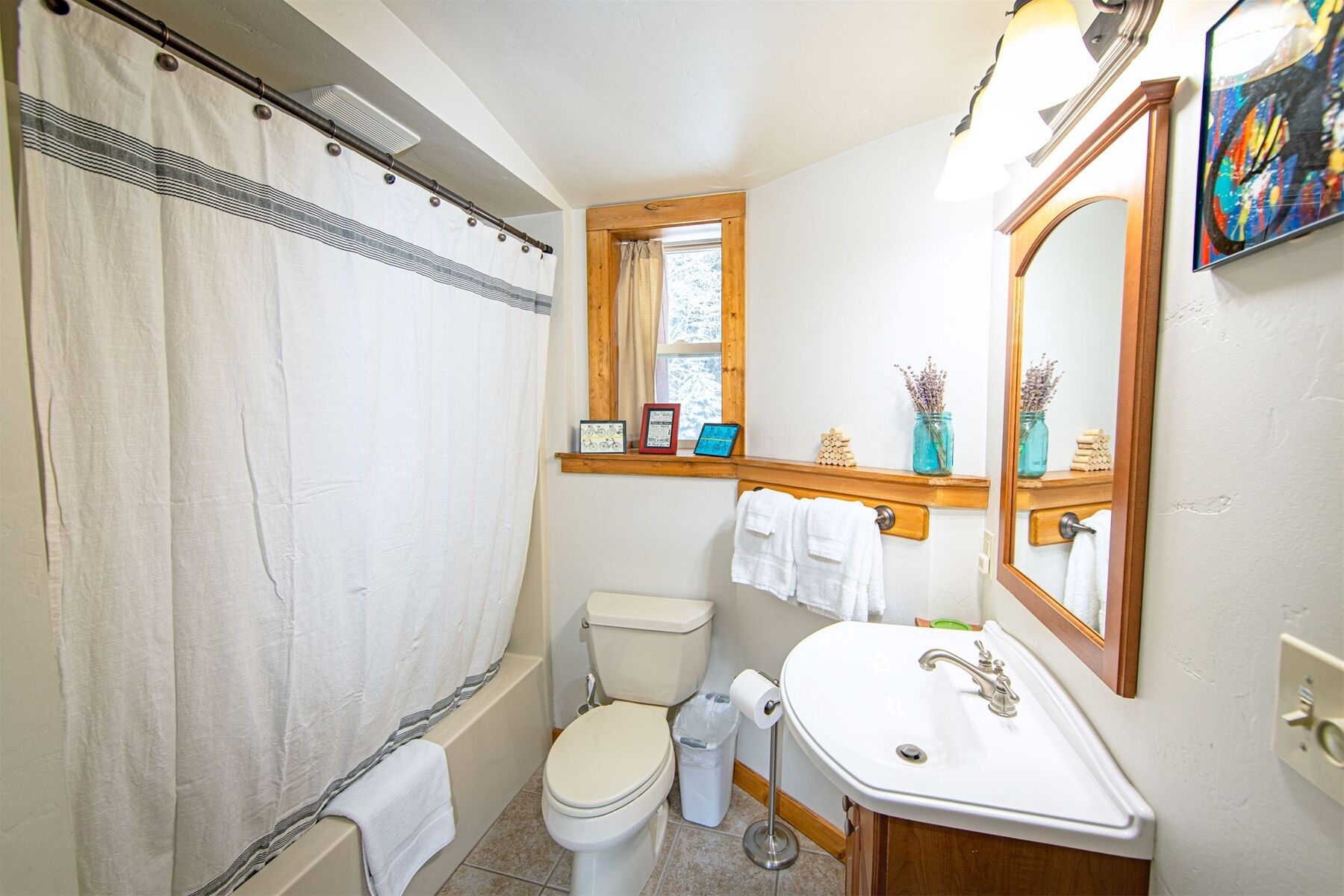 Un baño con inodoro, lavamanos y cortina de ducha.