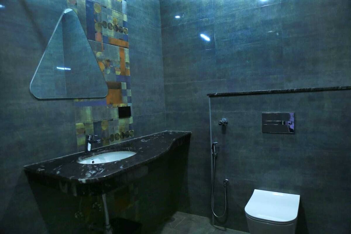 A bathroom with a sink, mirror, shower, and toilet.