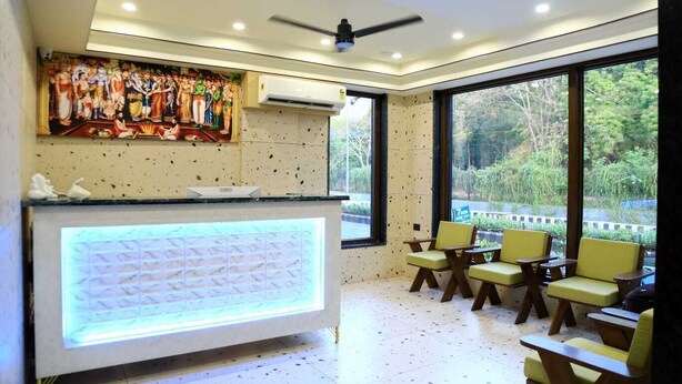 Un espace d’accueil au design moderne, comprenant un comptoir d’accueil, un coin salon et de grandes fenêtres offrant une vue sur l’extérieur.