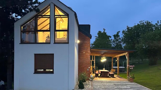A modern house with a large glass window, a wooden pergola, and a patio area. - Pet friendly home in Durdevac (Durdevac)