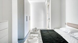 A modern hotel room with a bed, a wardrobe, and a bathroom visible. - GuestHost - Casa Frida, apartement with balcony (Foligno)