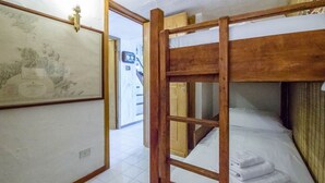 A room with a bunk bed, a framed map on the wall, and a door leading to another room. - GuestHost - Dreamy Sea View with Pool and Parking (Olbia)