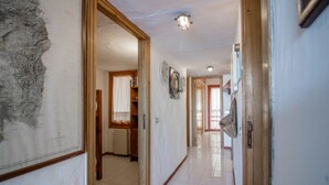 A hallway with a map, wooden doors, and a tiled floor. - GuestHost - Dreamy Sea View with Pool and Parking (Olbia)
