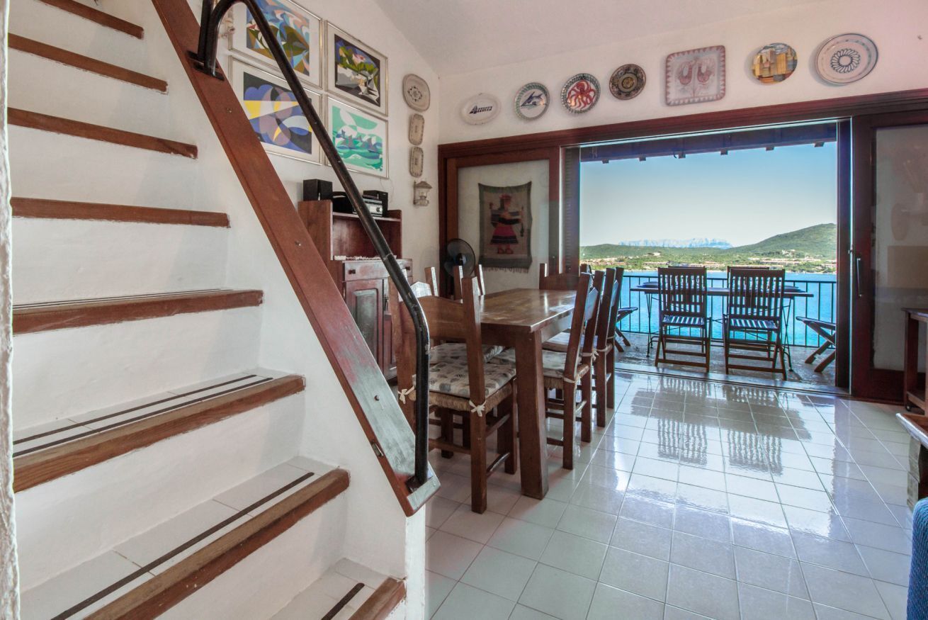 A staircase leading to a balcony with a view of the sea.