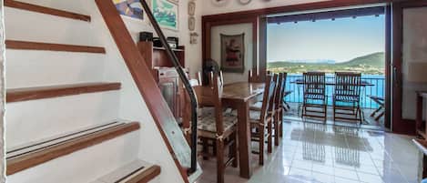 A staircase leading to a balcony with a view of the sea.