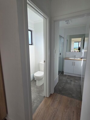 Une salle de bain moderne avec des toilettes, un lavabo et un miroir.