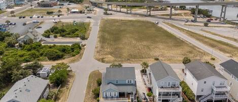 A coastal residential area with houses, a swimming pool, and a beach in the background.