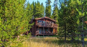 Eine Holzhütte mit Balkon und einer Terrasse.