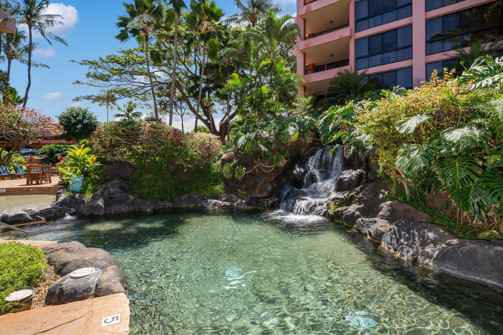 Serene outdoor oasis featuring a tranquil waterfall and lush landscaping