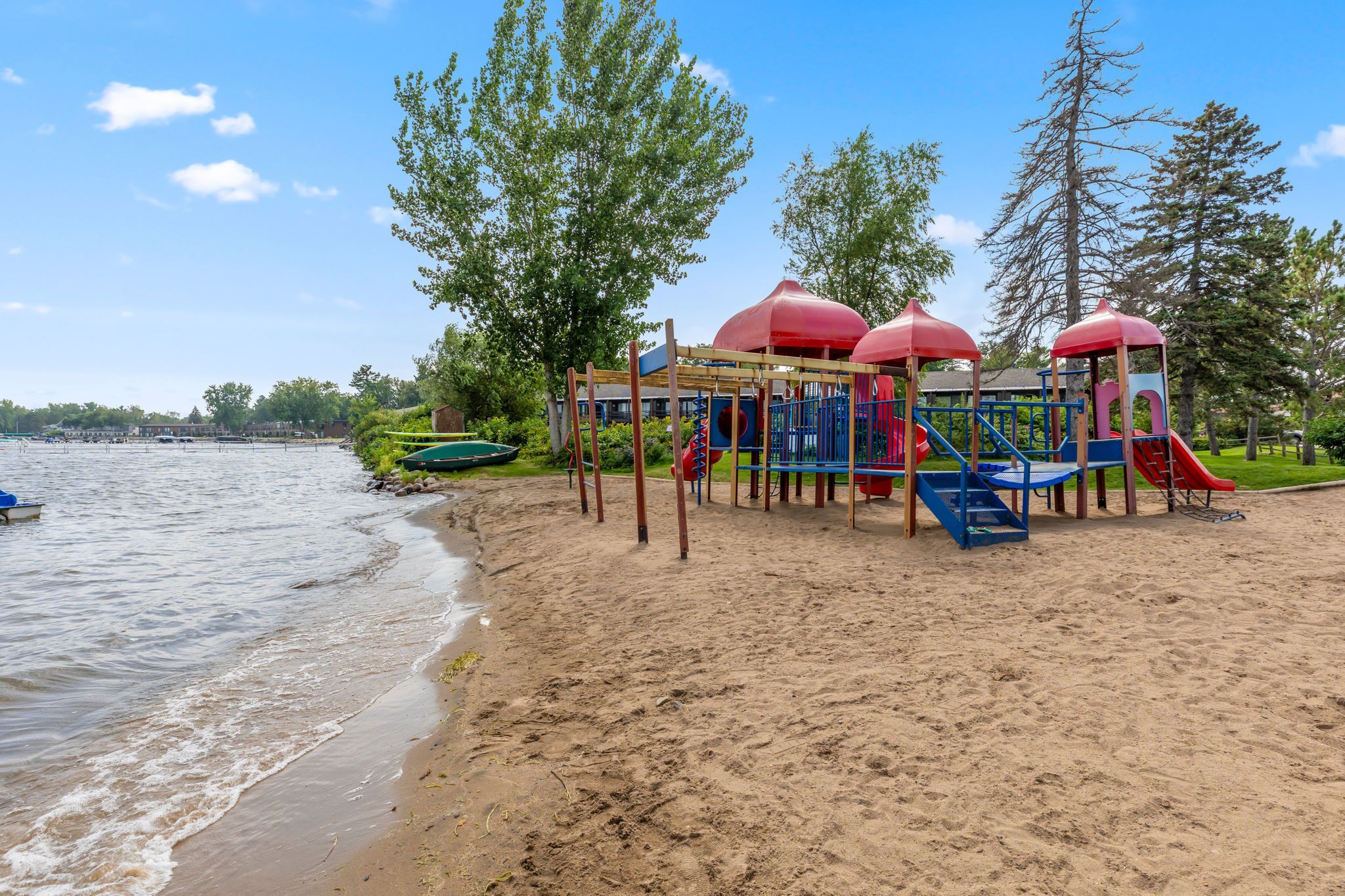 Sandy beach with a colorful playground set right by the water.