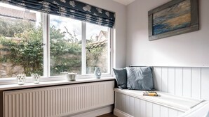 Ein gemütliches Zimmer mit Fensterbank, Heizkörper und einem Bild an der Wand.