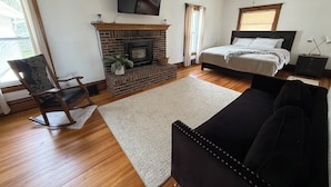 A bedroom with a bed, a fireplace, a TV, and a ceiling fan. - Cozy Farmhouse Getaway 10 min from Lost Island and Casino (La Porte City)