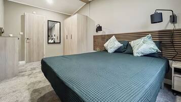 Une chambre à coucher avec un lit, une armoire, un miroir et une table de chevet.