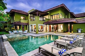 A two-story building with a swimming pool and outdoor seating area. - Exclusive Luxury Villa at Reserva Conchal w/ Pool –Just 10 Min Walk to the Beach (Playa Conchal)