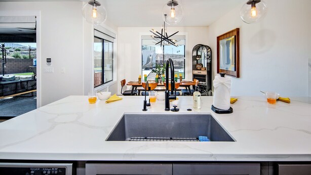 A modern kitchen with a large island, stainless steel appliances, and a view to the outside. - Villa Solara – Ultimate Backyard & Gameroom (Lake Havasu City)