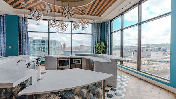 Una cocina moderna con una isla curva, ventanas amplias y vista a la ciudad.