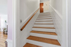 Een trap met houten treden en een houten leuning, die leidt naar een verdieping.