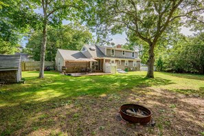A two-story house with a covered patio and a fire pit in the yard. - Family & Pet-Friendly Cape Escape Near Beach (Hyannis)