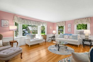 A room with two white sofas, a round coffee table, and a pink wall. - Family & Pet-Friendly Cape Escape Near Beach (Hyannis)