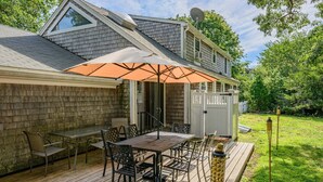 A deck with a table and chairs, a white fence, and a satellite dish. - Family & Pet-Friendly Cape Escape Near Beach (Hyannis)