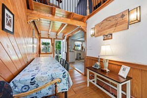 A wooden interior with a dining area, a kitchen, and a wall-mounted compass. - Family & Pet-Friendly Cape Escape Near Beach (Hyannis)