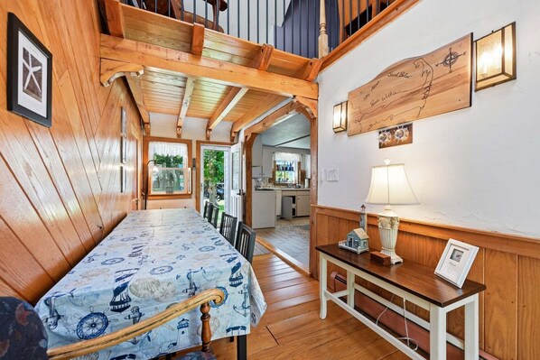 A wooden interior with a dining area, a kitchen, and a wall-mounted compass.