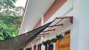 A covered outdoor area with a table and chairs, potted plants, and a fire extinguisher. - Amwani Residence - Kalikasan Homes (Puerto Princesa)