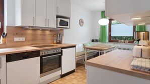 A modern kitchen with a dishwasher, oven, microwave, and a wooden countertop. - Apartment '1' with Mountain View, Private Terrace and Wi-Fi (Sankt Peter)