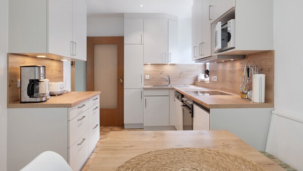 A modern kitchen with white cabinets, a wooden countertop, a built-in oven, and a microwave. - Apartment '1' with Mountain View, Private Terrace and Wi-Fi (Sankt Peter)