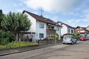 Eine Wohnstraße mit Häusern, einem Auto und einem Garten.