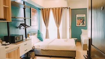 A modern bedroom with a bed, bedside tables, a wardrobe, and a bathroom.