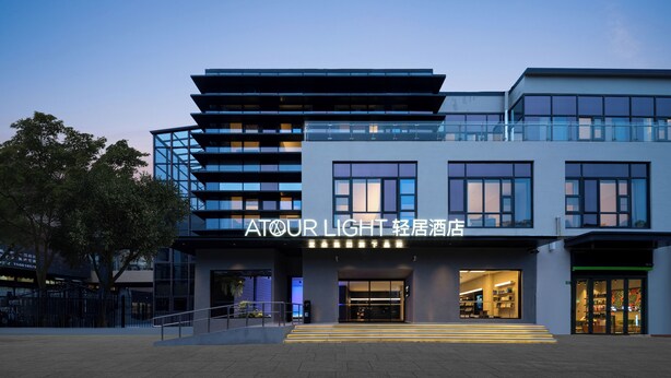 A modern hotel with a prominent sign reading "ATOUR LIGHT."