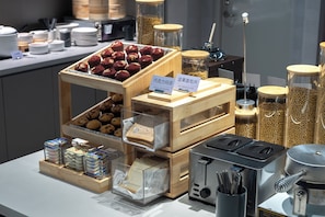 A buffet setup with various food items, including muffins, sandwiches, and jars of nuts. - Atour Light Shanghai Pudong Airport Shixin Road Hotel (Shanghai)