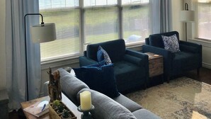 A living room with two sofas, a table with a candle, and a lamp.
