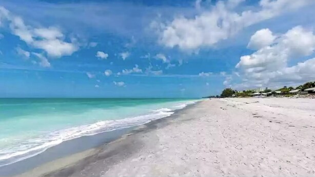 Una playa con agua turquesa cristalina y una orilla arenosa.