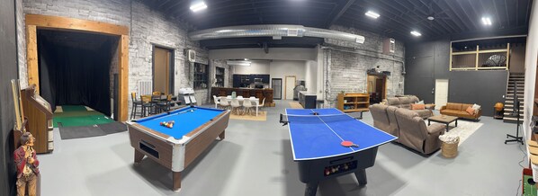 Amplio espacio interior con mesa de billar, mesa de ping pong y mesa de futbolín.