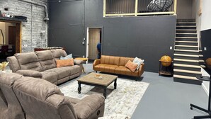Une pièce spacieuse avec des canapés en cuir, une table basse en bois et un grand globe terrestre posé sur un socle.