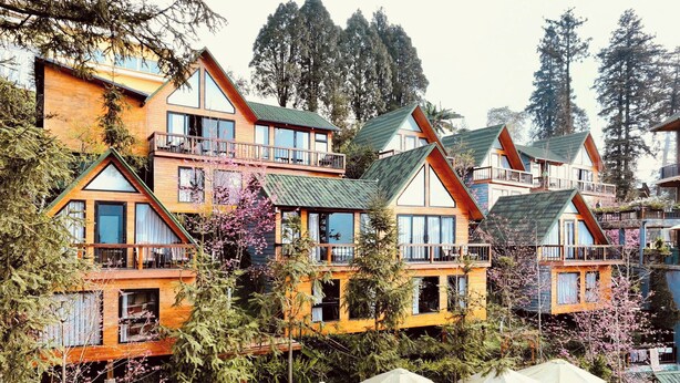 Un bâtiment à plusieurs étages, doté de balcons, d’une façade en bois et d’espaces de détente en plein air.