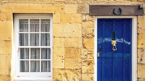 Un edificio con una ventana y una puerta azul, con la inscripción 
