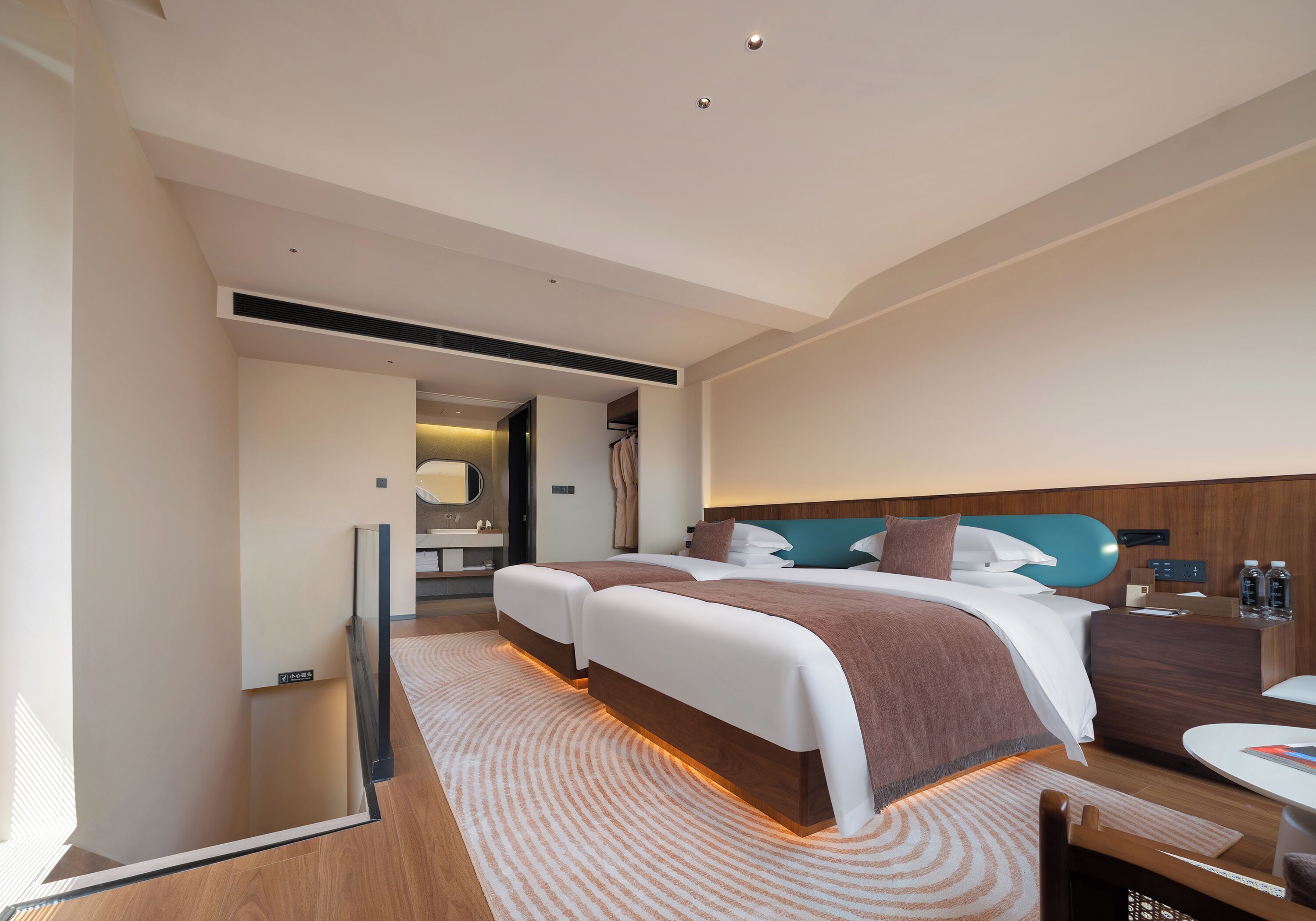 A modern hotel room with a large bed, a desk, and a seating area.
