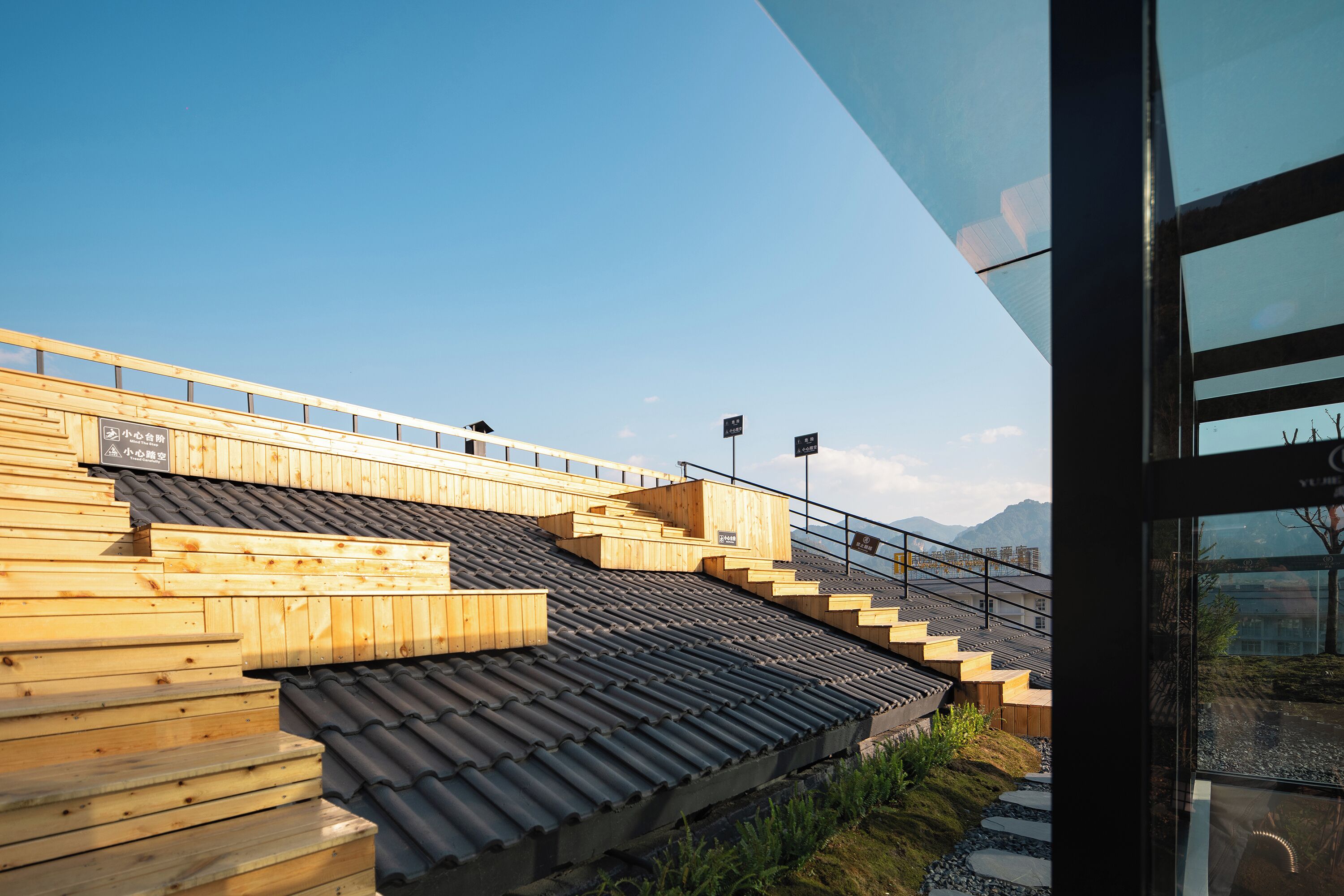 A wooden staircase leading to a terrace with a view of mountains.