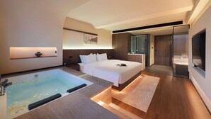 A modern hotel room with a large bed, a separate bathtub, a flat-screen TV, and a walk-in closet. - YUJIE HOTEL (Zhangjiajie)